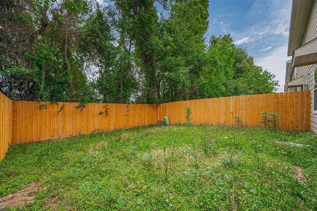 Freshly updated wooden fence, lush greenery, and mature trees providing privacy and a natural backdrop. Ideal for outdoor activities or gardening.