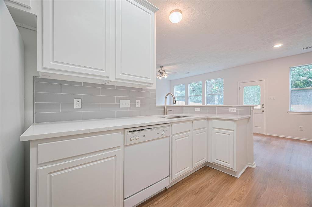 Discover elegance in the kitchen with sleek quartz countertops and a stylish tile backsplash.