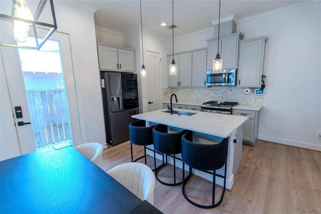 Open concept kitchen / dining combo. Modern fixtures, lighting, and luxury vinyl plank floors, breakfast bar/island