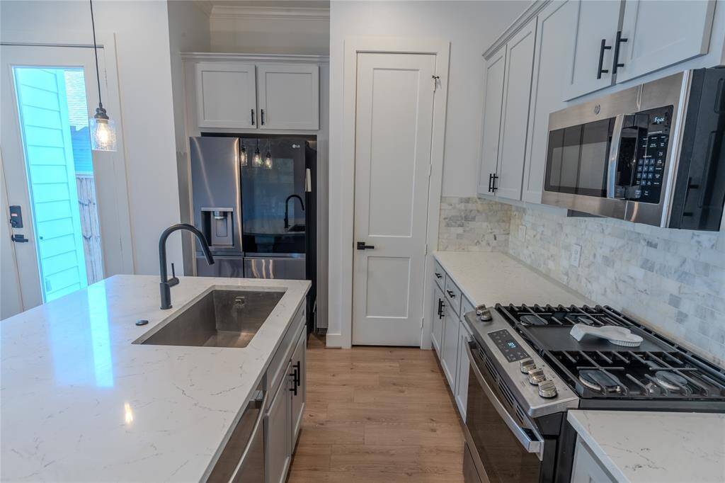 Stainless steel appliances, deep stainless farm sink. Door leads to walkin pantry.