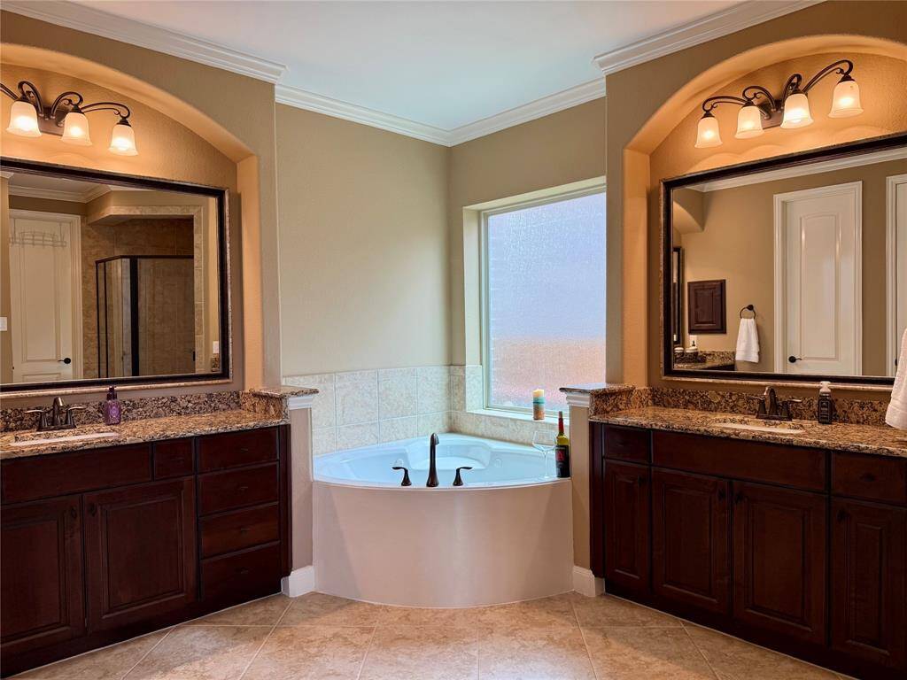 double vanity en suite primary bathroom with a jacuzzi corner tub!