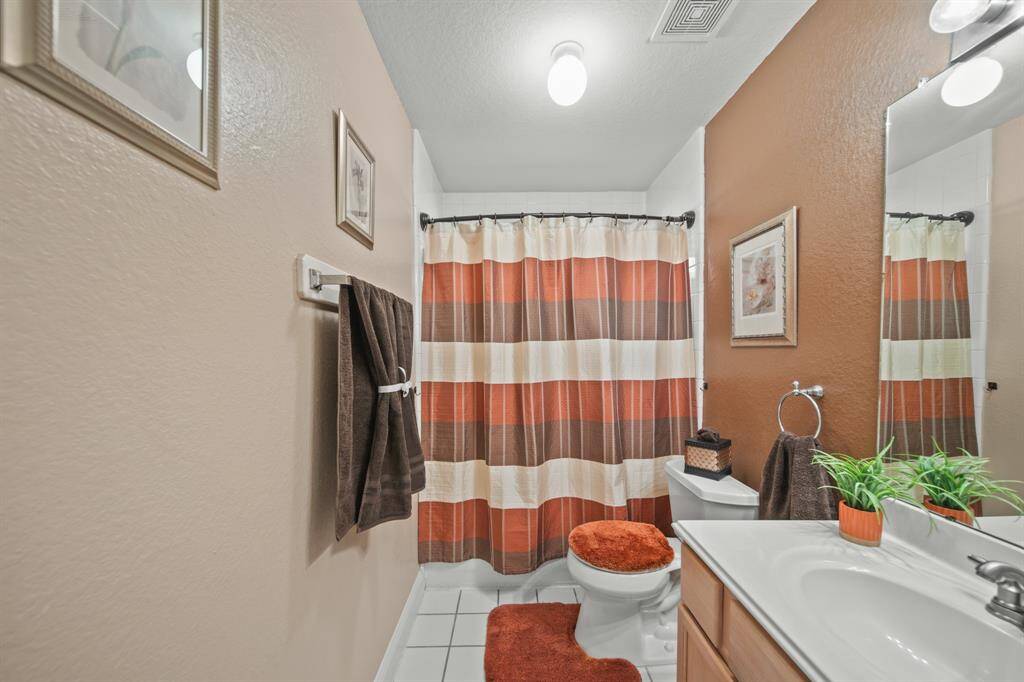 This bathroom features a warm color palette with brown and orange accents. The space is well-lit and has a clean, modern feel.
