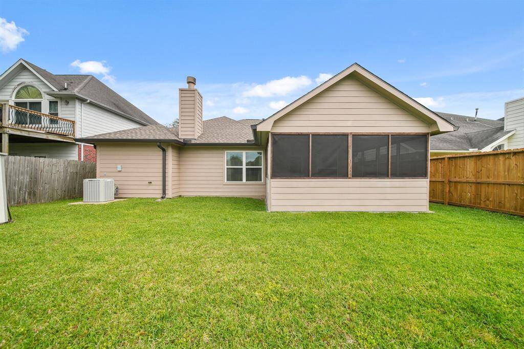 Spacious and fenced backyard surrounded by lush greenery, offering a serene and private outdoor retreat.