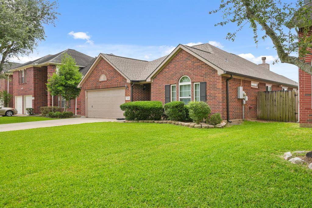 This charming single-story brick home features a well-maintained lawn, a two-car garage, and attractive landscaping. Its clean, classic design includes arched windows and a fenced backyard, ideal for families seeking a cozy suburban setting.