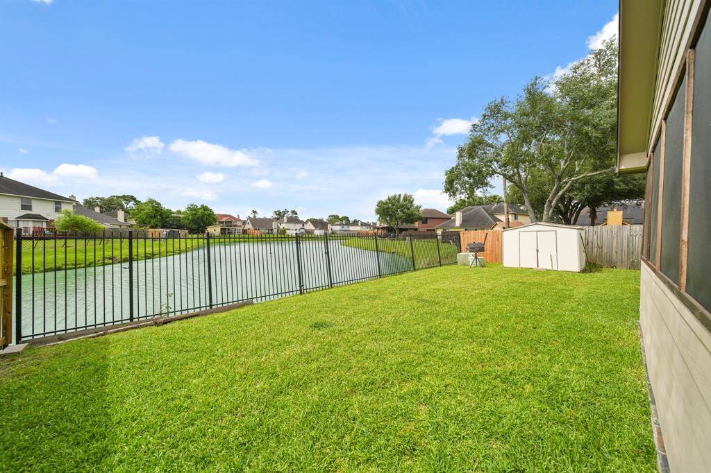Spacious and fenced backyard surrounded by lush greenery, offering a serene and private outdoor retreat.