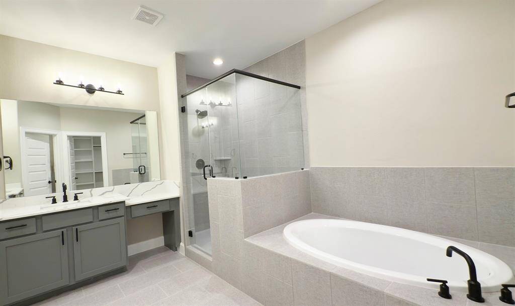 Step into a sanctuary of sleek sophistication with this luxurious bathroom, a symphony of modern design and comfort. *Image depicts home as-is.