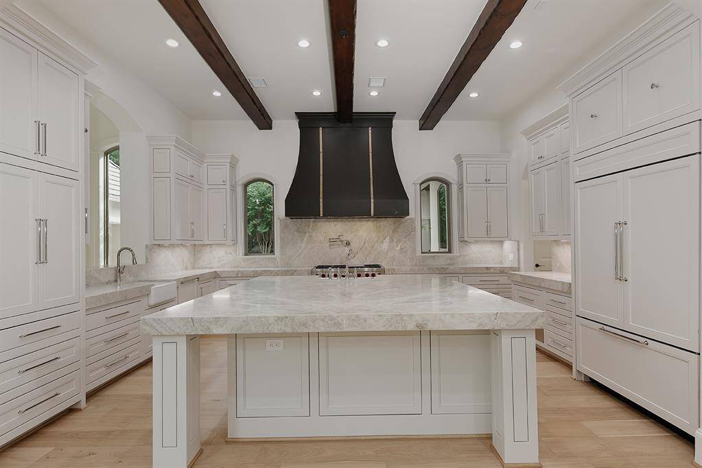 This expansive kitchen with enormous island, Taj Mahal quartzite counters with 4 inch miter, SubZero fridge, Wolf gas range with pot filler, warming drawer, two sinks and two dishwashers will be a thrill to cook in!