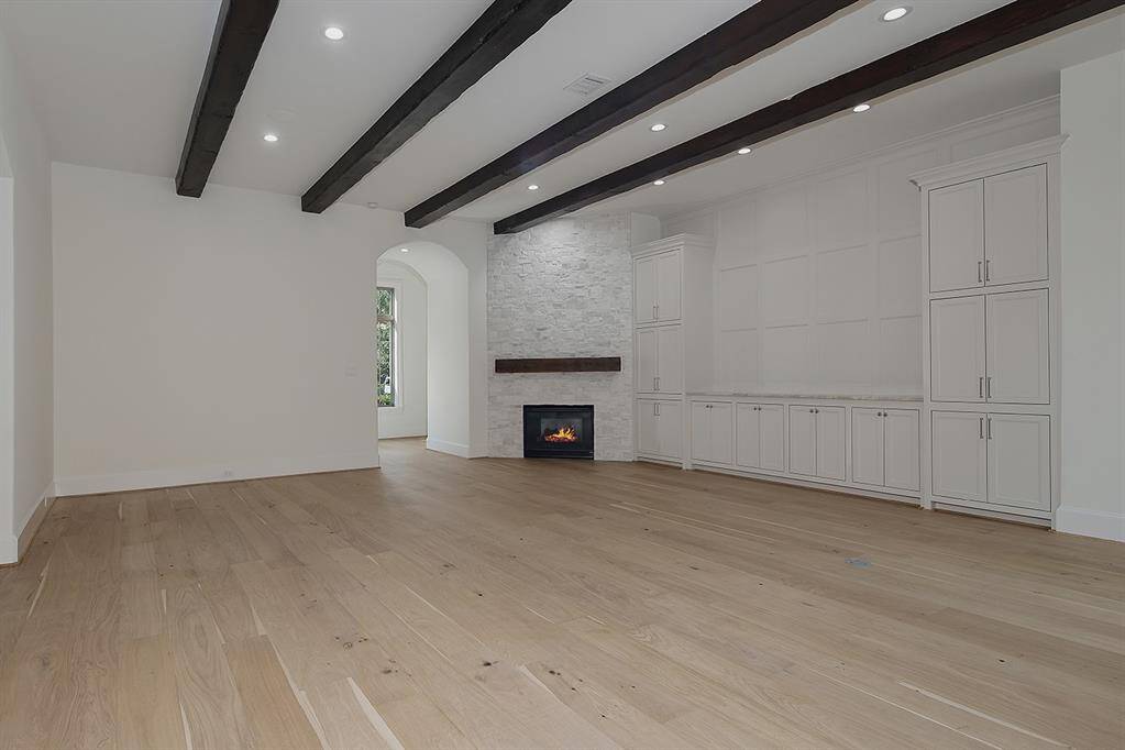 The consistent French oak floors are a stunning contrast to the wood beam ceiling, and the fireplace has been refaced with a new mantle.