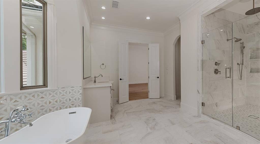 The natural light and beauty of this primary bath are incomparable! Her closet features a built-in custom vanity.