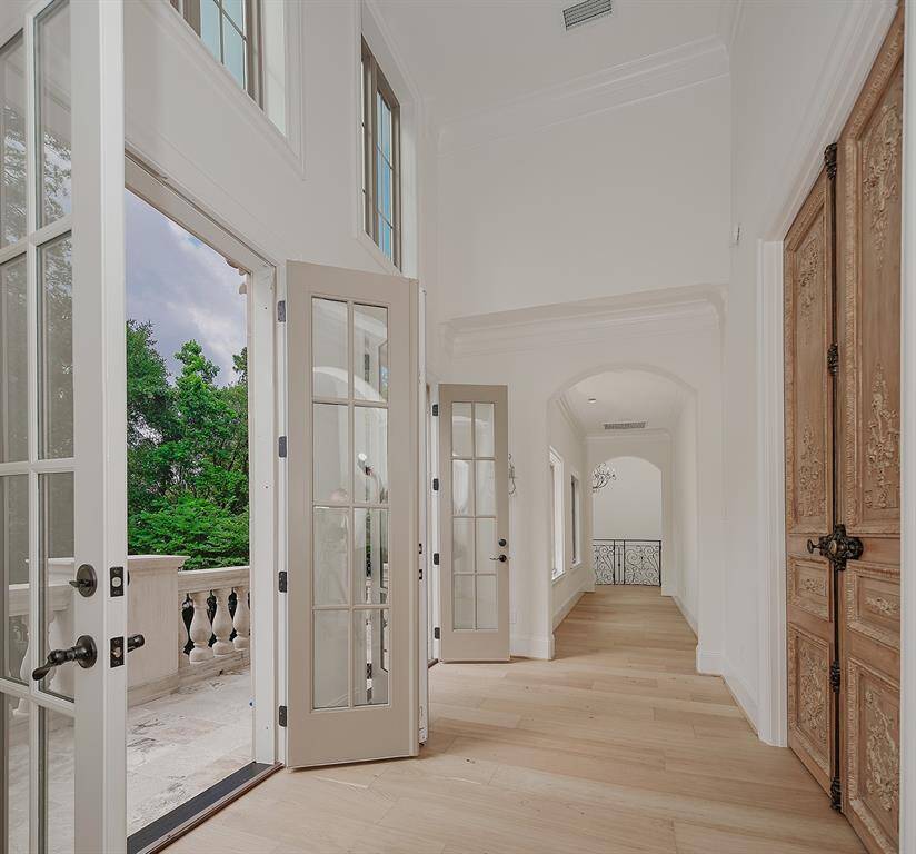The wide hallway, consistent French white oak floors, sky high ceiling heights and detailed trim work are highlighted in this photo.