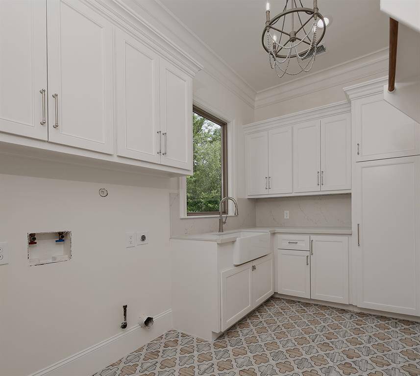 The laundry room is functional and beautiful, with a sink, hanging area and plenty of cabinetry and counter space for folding.