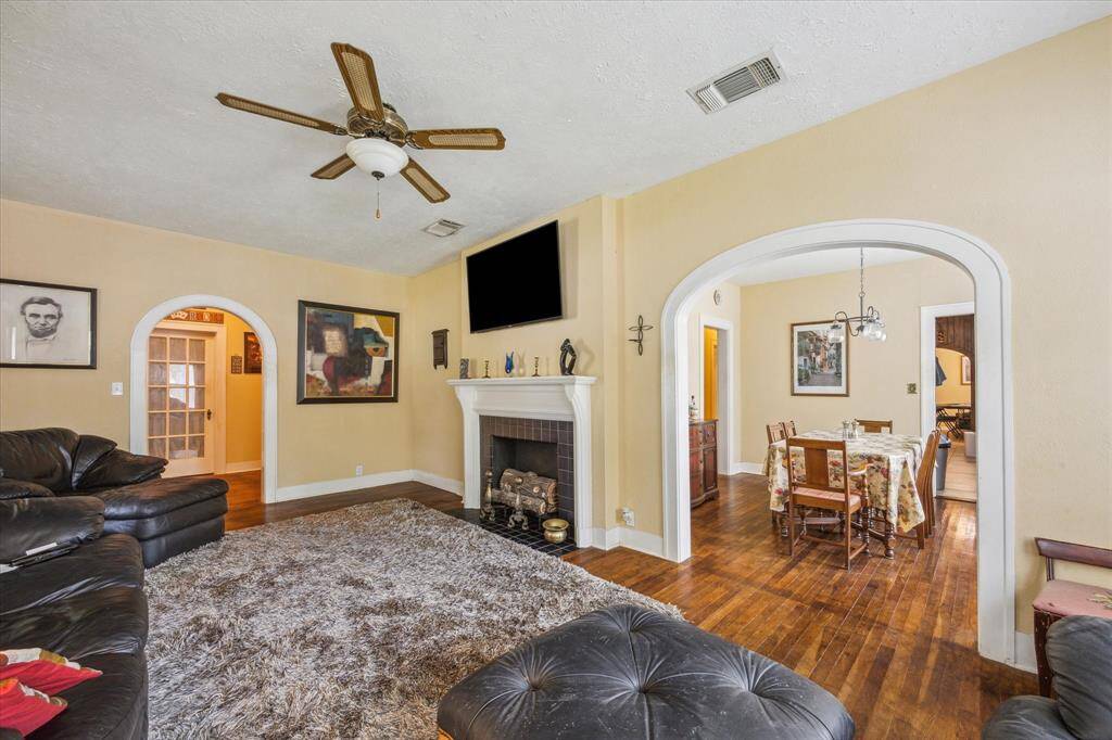 The updated gas fireplace is the centerpiece here, framed by rich hardwoods and a stunning original archway leading into the formal dining—details like this are rarely found anymore!