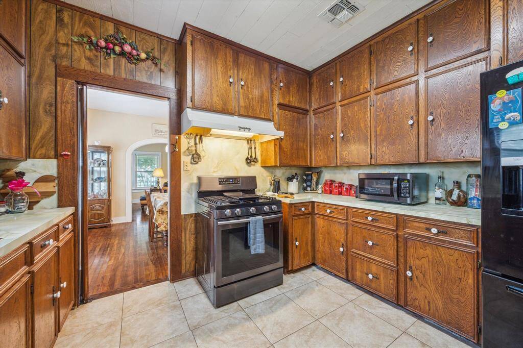 Mid-century vibes meet timeless charm—this view shows the connection to the formal dining through a classic pocket door, plus a glimpse of the abundant cabinetry this kitchen offers.