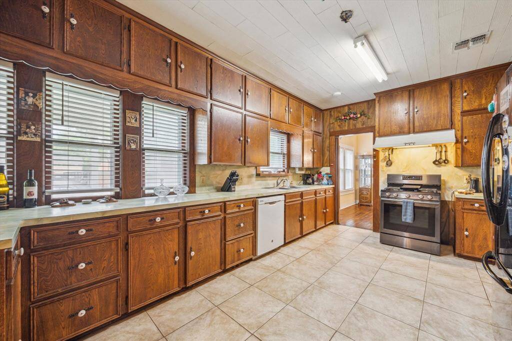 A cheerful and bright space to start your day—kitchen sink sits below three large windows, flooding the room with natural light.