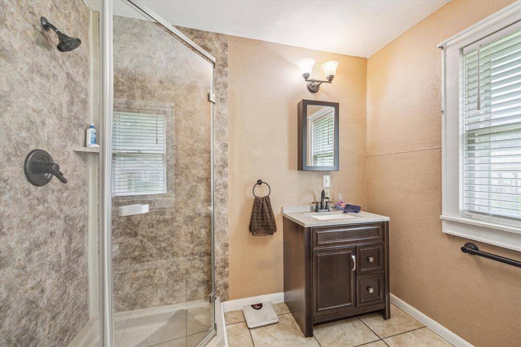 The private ensuite master bath features a sleek new standing shower and a thoughtfully designed single-sink vanity—offering both style and function with just the right amount of space to keep things simple and serene.