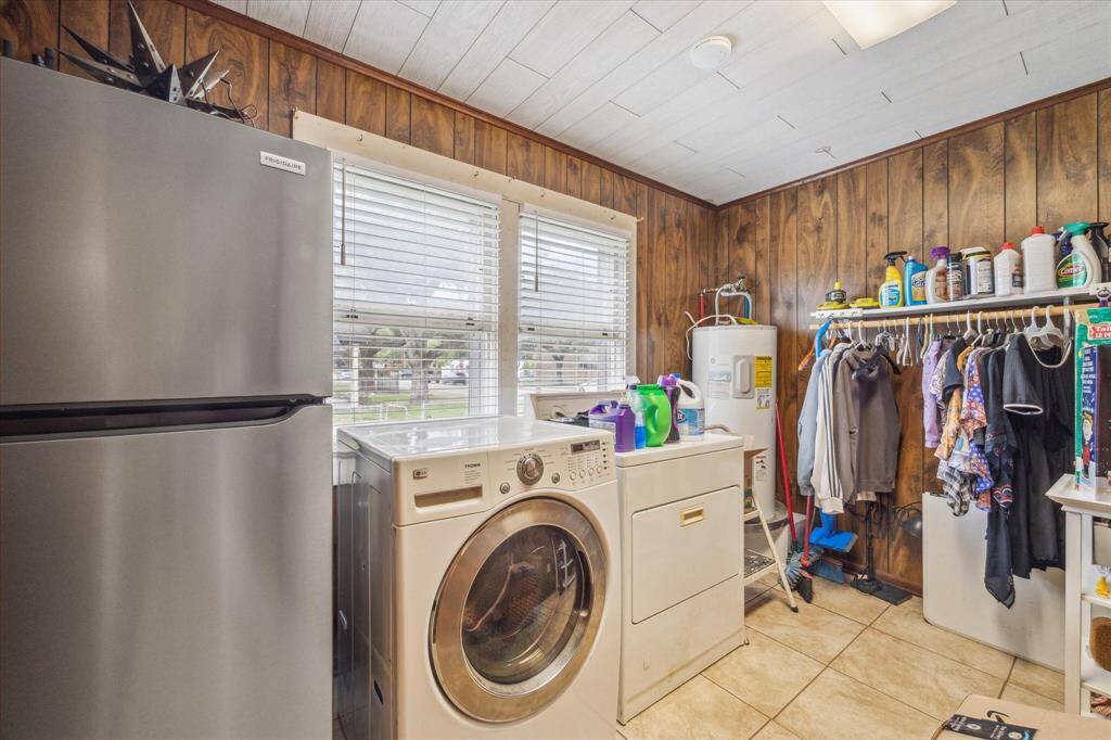 Spacious laundry room with plenty of room to hang clothes, fold, and organize. The water heater is smartly located here, and a window brings in natural light, making the space feel open and functional.