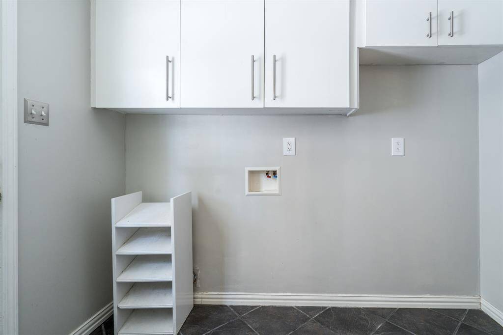 Utility room has space for a fridge in addition to a washer and dryer.