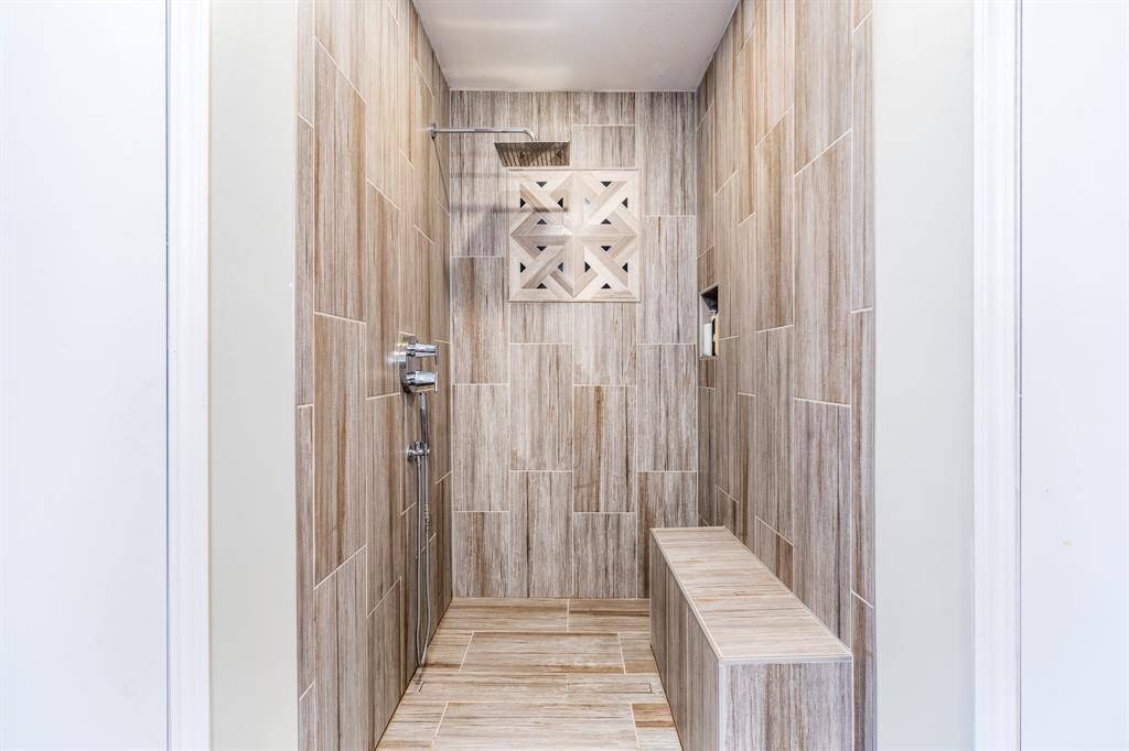 Walk-in shower with a bench.