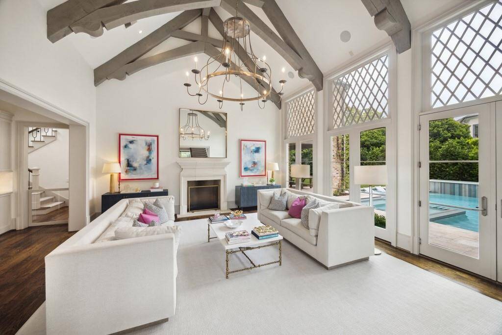 This angle captures the perfect balance of scale and softnesss. Natural light pours through the grid-patterned windows, while the open connection to the foyer creates a cohesive flow between formal and casual living spaces.