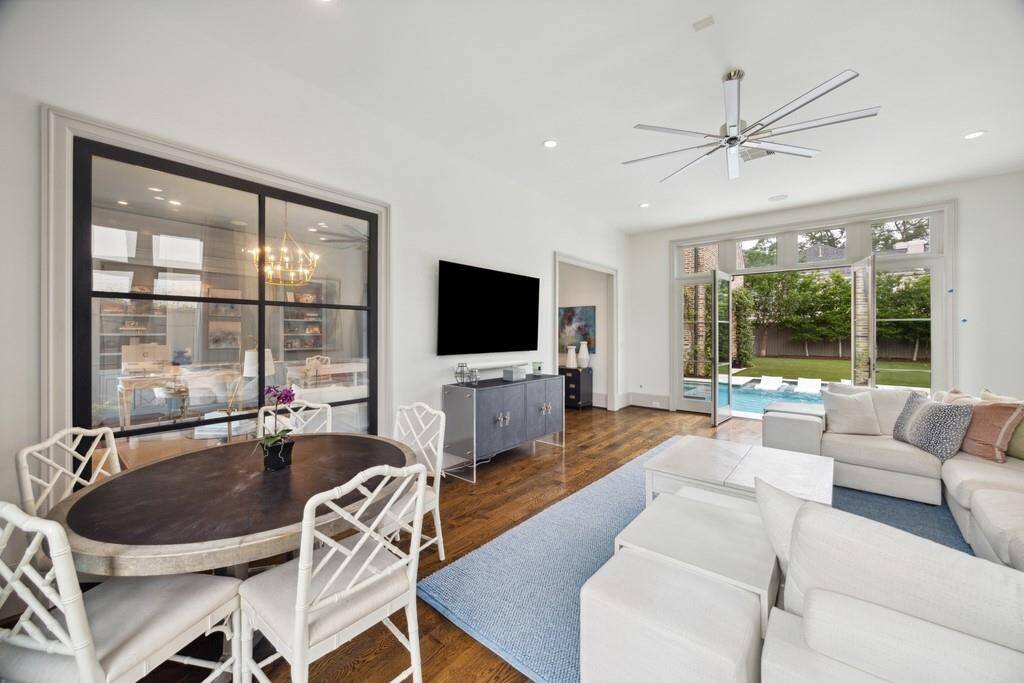 Another view of the downstairs playroom reveals direct access to the backyard and pool, along with a clear view into the lacquered office through sleek steel-framed glass doors.