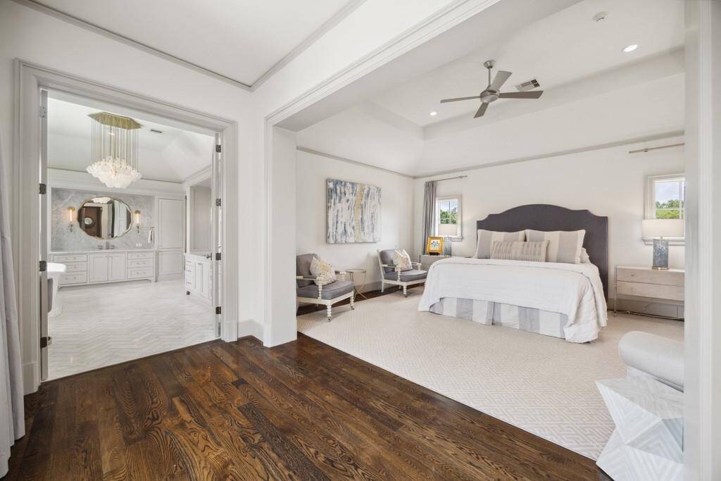 Elegant primary suite with vaulted ceilings, hardwood floors, and a spacious layout with sitting area and en-suite access.