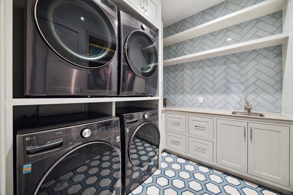 Spacious laundry room with stacked washers and dryers.