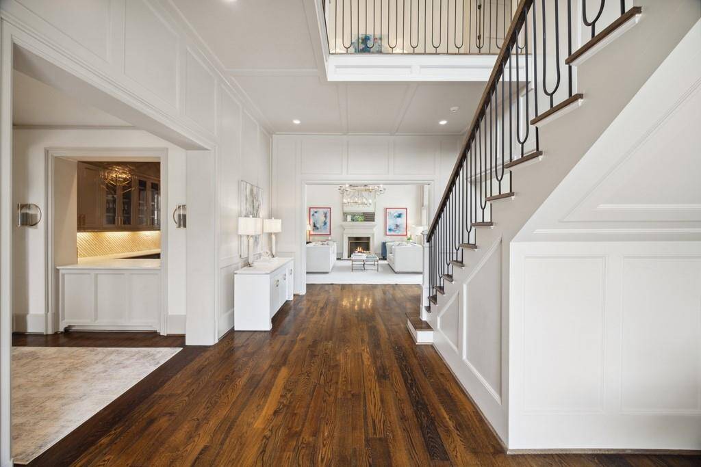 You are welcomed by an elegant entry with rich hardwoods, custom trim, and a striking staircase—luxury and warmth from the moment you walk in.