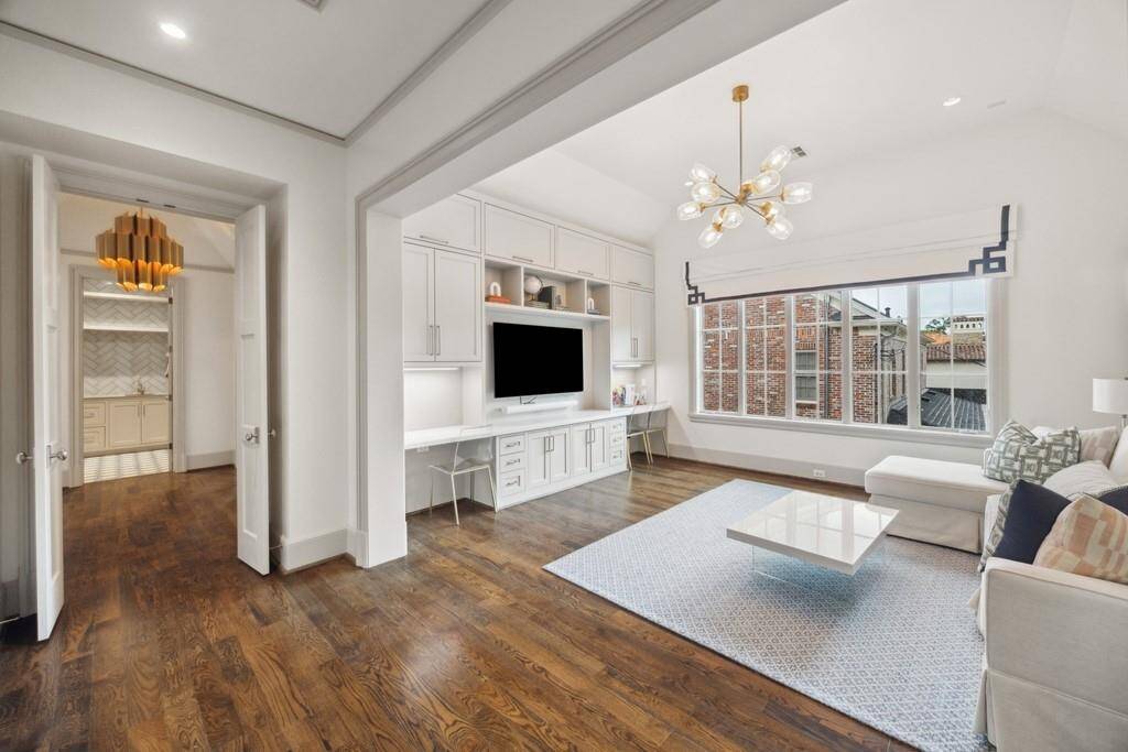This spacious upstairs flex room offers endless possibilities with built-in cabinetry, dual desks, and a large media center—perfect for work, study, or play.