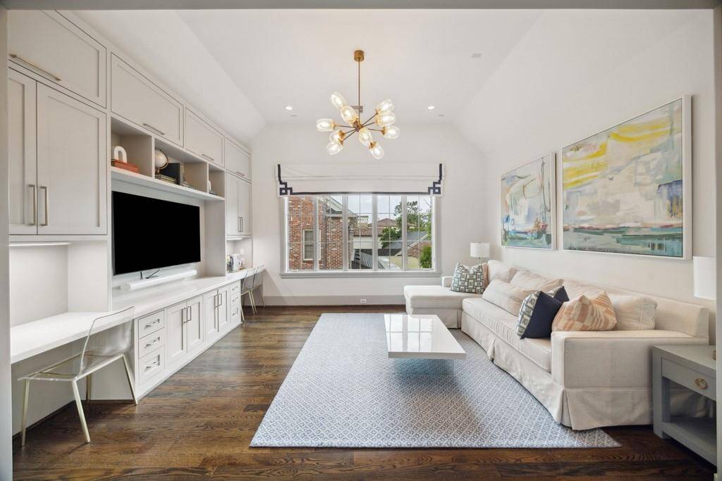Another view of the upstairs game room with oversized windows and modern lighting create an airy, inviting atmosphere.
