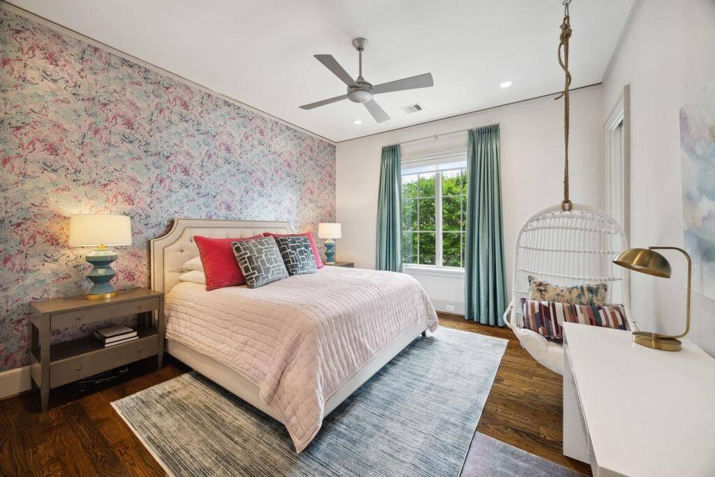 One of five bedrooms, this spacious suite features large windows, hardwood floors, a walk-in closet and a private en-suite bath.