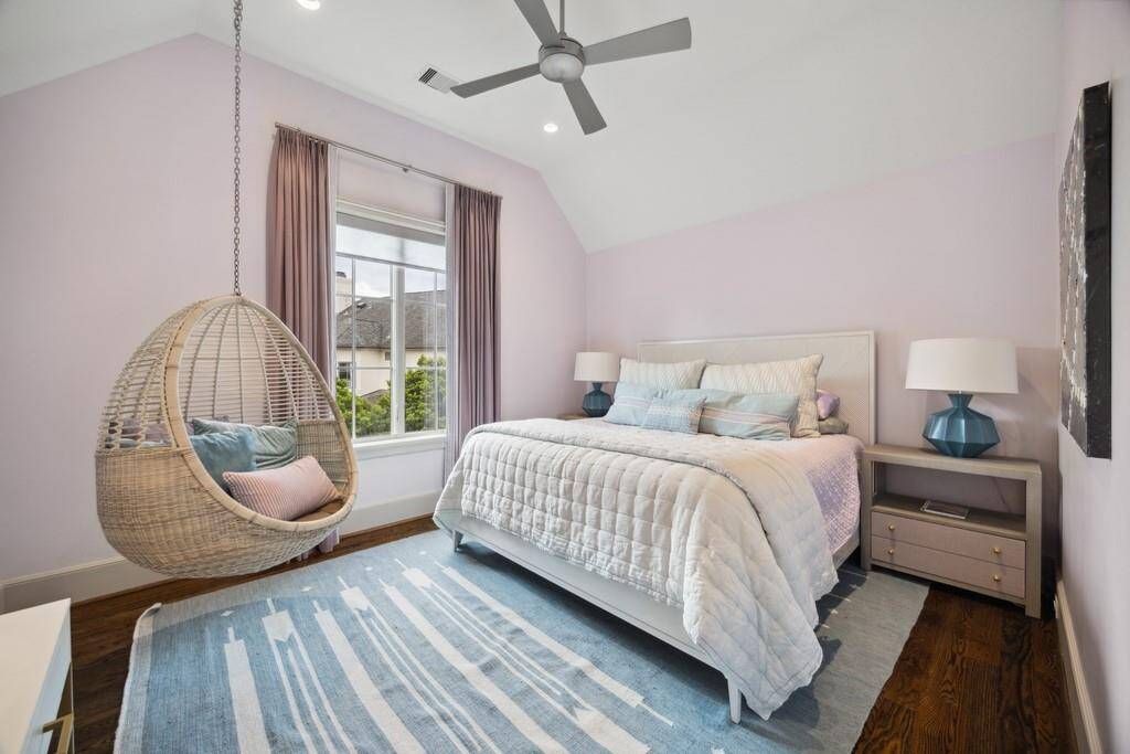 One of five bedrooms, this spacious suite features large windows, hardwood floors, a walk-in closet and a private en-suite bath.