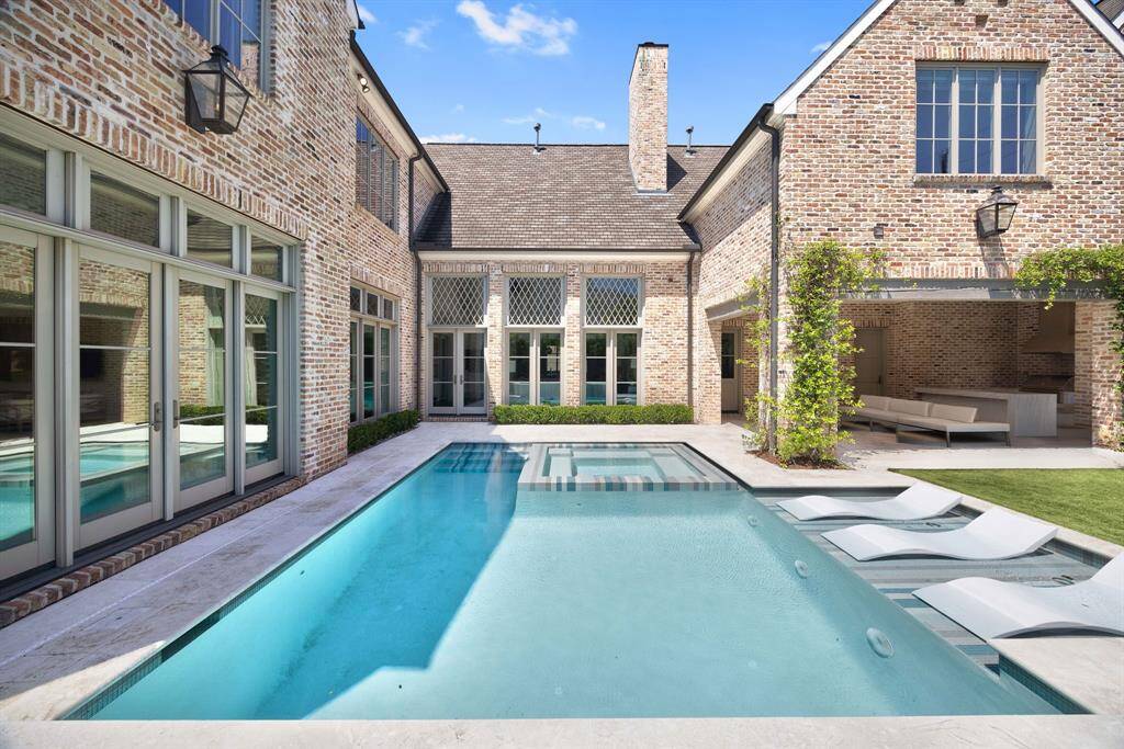 A striking view of the pool, beautifully framed by floor-to-ceiling windows with custom lattice detailing. The symmetry, natural light, and architectural elegance create a truly breathtaking outdoor living experience.