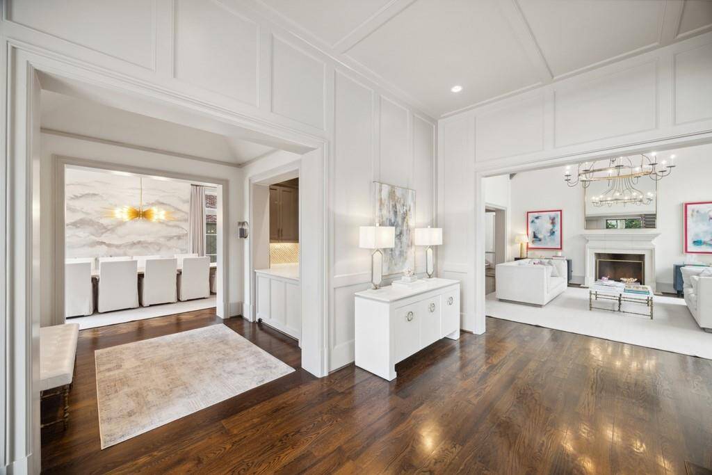 From this vantage point, the timeless paneling takes center stage, framing a seamless flow between the formal dining room, stylish wet bar, and elegant living area.