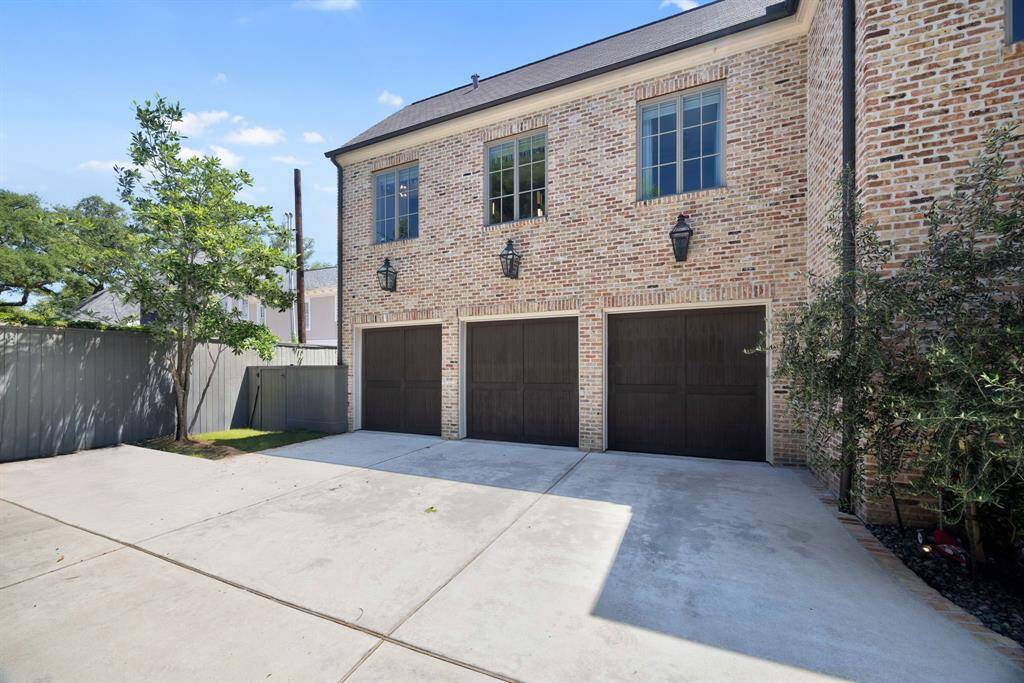 A spacious three-car garage is complemented by an extended driveway, offering ample parking.