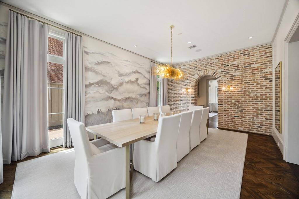 Another view of the dining room highlights the beautiful brick accent wall and arched entry leading to the butler’s pantry.