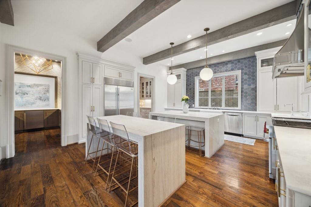 From this view of the kitchen, you can see the sophisticated bar and butler’s pantry, which leads seamlessly to the formal dining room—perfect for effortless entertaining.