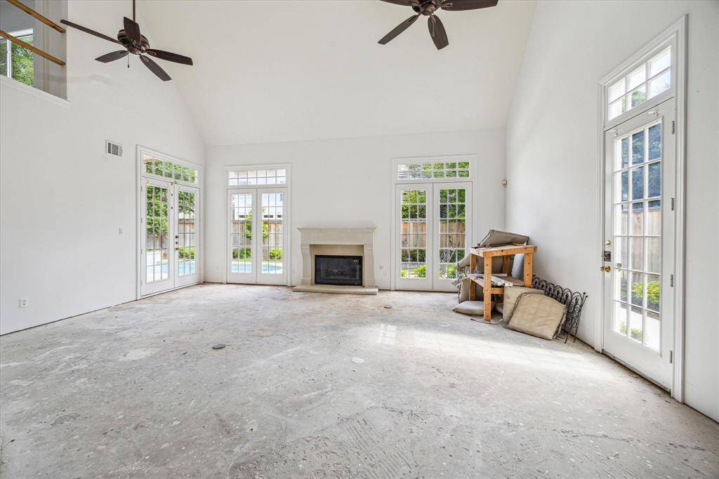 Walls of windows and French doors flood the living area with sunlight, offering seamless views of the backyard oasis and endless potential for custom finishes.