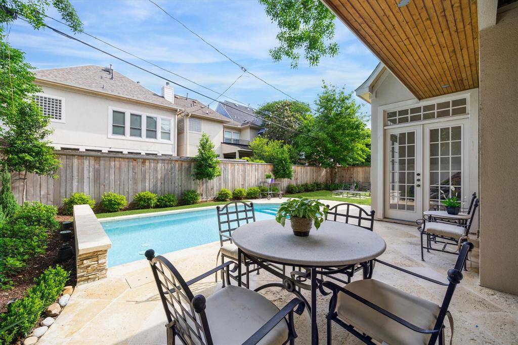 Enjoy alfresco dining under the covered patio, with views of the sparkling pool and beautifully landscaped yard.