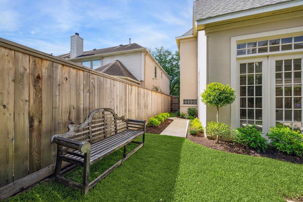 A peaceful side yard with a garden path and seating nook adds even more outdoor versatility and charm.