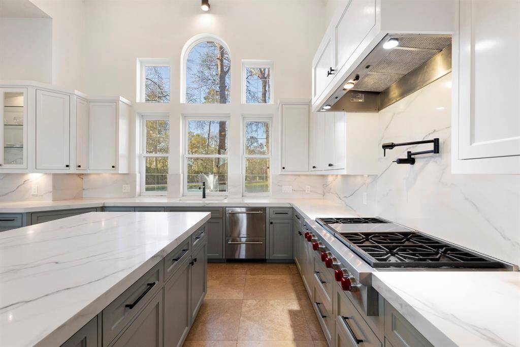 The gleaming bright and airy ambiance with soft-close cabinets set the stage for gourmet adventures, while under-cabinet lighting, pot filler and gas cooktop adds a touch of modern sophistication.