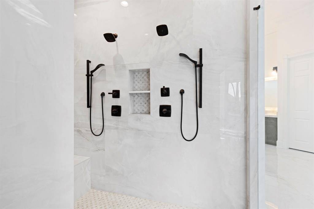 This elegantly appointed dual shower, featuring chic matte black fixtures against sleek, tile details. Ideal for a relaxing escape or rejuvenating start, ensuring even the most mundane Monday mornings begin with a hint of grandeur.