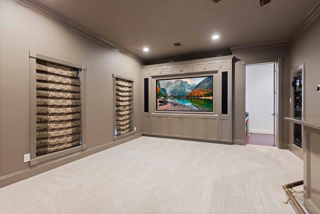Indulge in cinematic splendor within your own home! This elegantly appointed media room boasts a state-of-the-art entertainment system, promising an immersive viewing experience that rivals any theater. With plush carpeting and sophisticated cabinetry, this space effortlessly combines comfort with class—perfect for hosting unforgettable movie nights or binge-watching marathons.