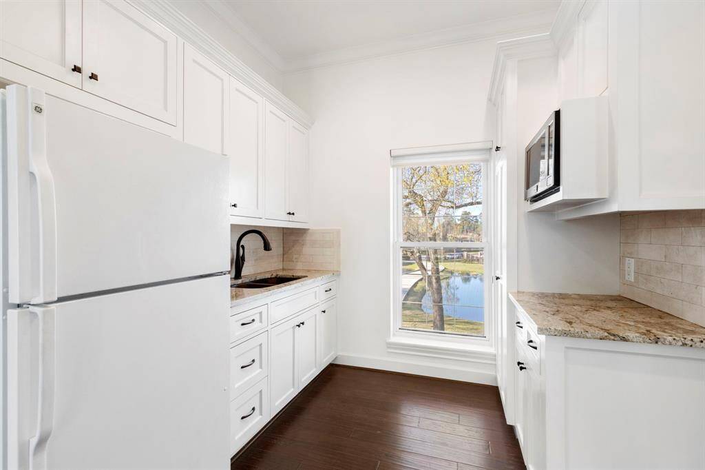 The kitchenette has updated cabinets and granite countertops with ample storage, sink, microwave, and refrigerator.