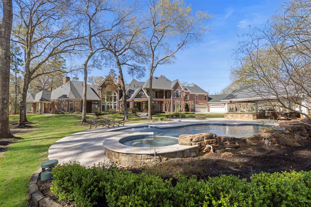 This lush estate boasts a sun-drenched backyard with a heated pool and inviting spa, perfect for both lively gatherings and peaceful reflection. Sheltered under majestic trees, the outdoor kitchen awaits culinary adventures, ensuring every alfresco meal becomes a memory to cherish.
