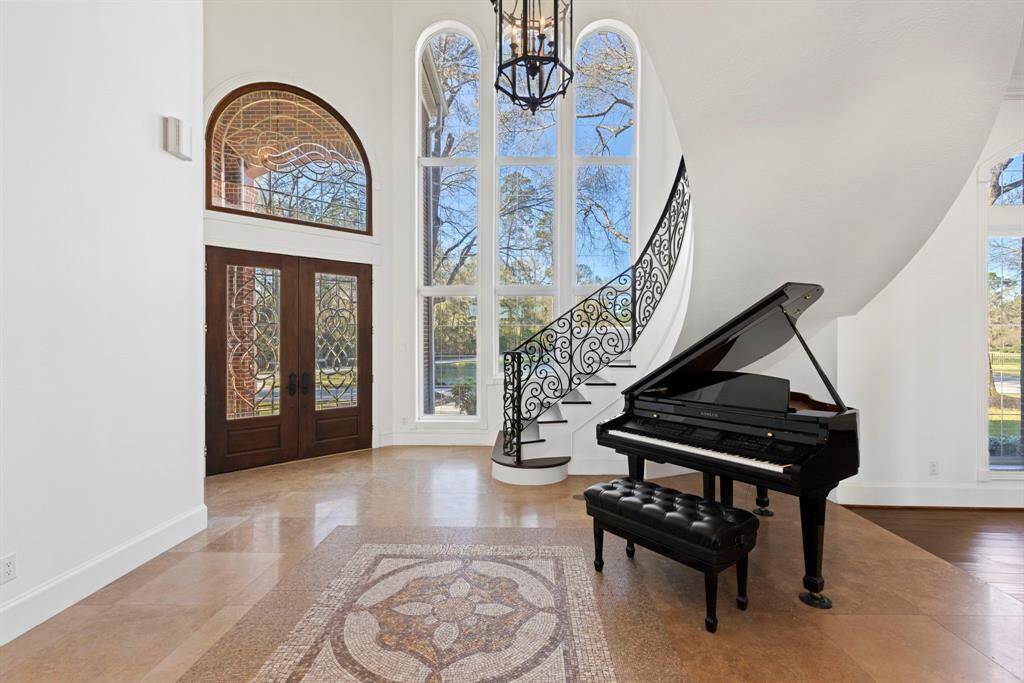 The grand foyer greets you with towering windows, perfect for a spectacular first impression, the space exudes sophistication with its exquisite flooring details that set the stage. A harmonious blend of grandeur and artistic flair awaits your appreciation.