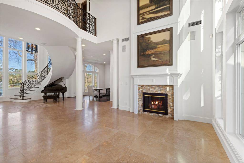 This exquisite space features a cozy fireplace, lofty ceilings, and expansive windows with views capturing nature's artistry.