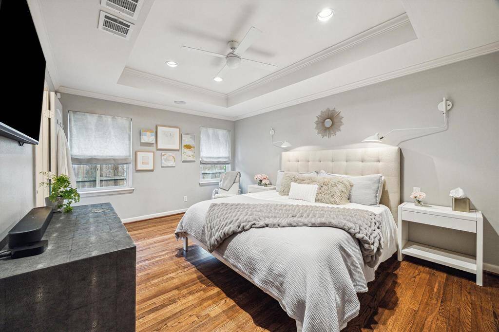 Primary bedroom with wood flooring.