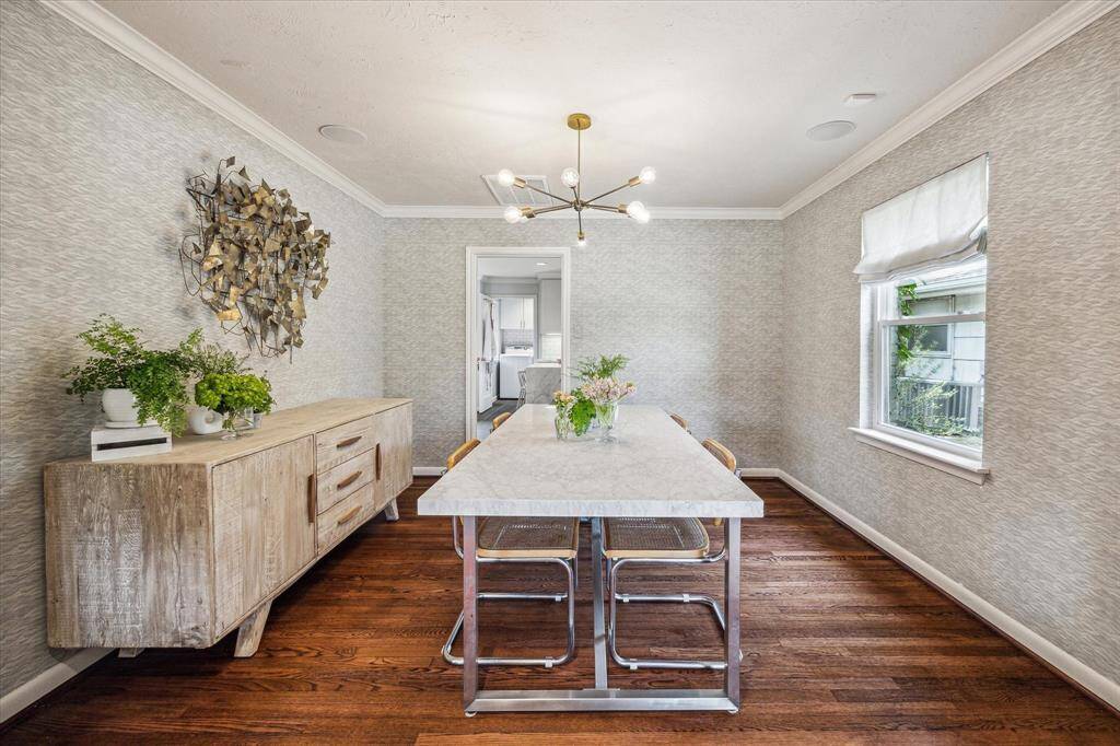 Dining room with wood flooring and Designer wall paper.