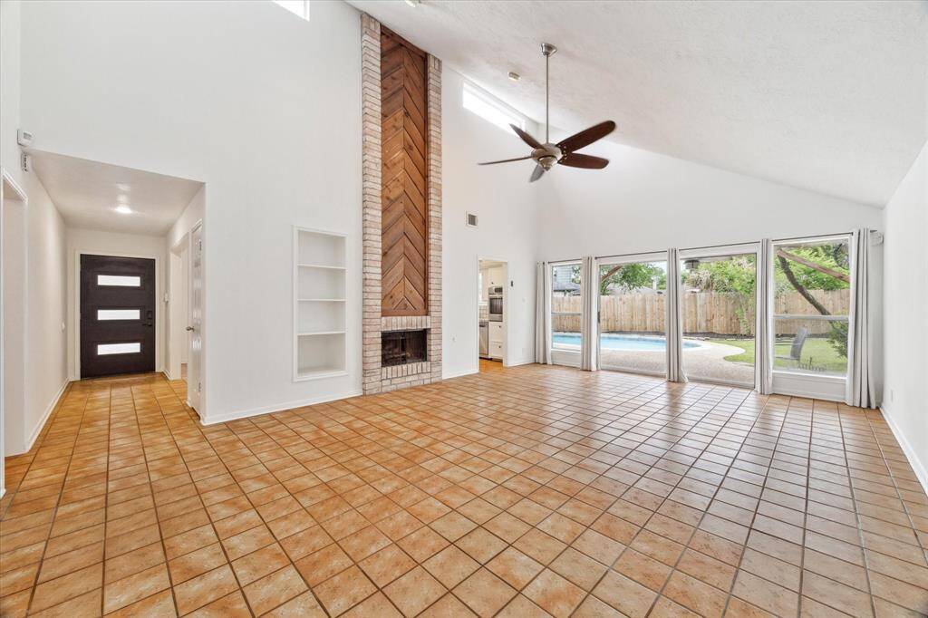 XL Living space with gorgeous brick floor to ceiling fire place featuring stunning wood design.