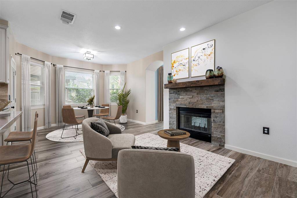 The eat-in kitchen is filled with natural light, creating a bright and welcoming space. The dual-sided fireplace, framed by a beautiful wooden mantle, adds a touch of elegance and warmth, making it a perfect feature for cozy meals and intimate gatherings. (This photo is virtually staged)